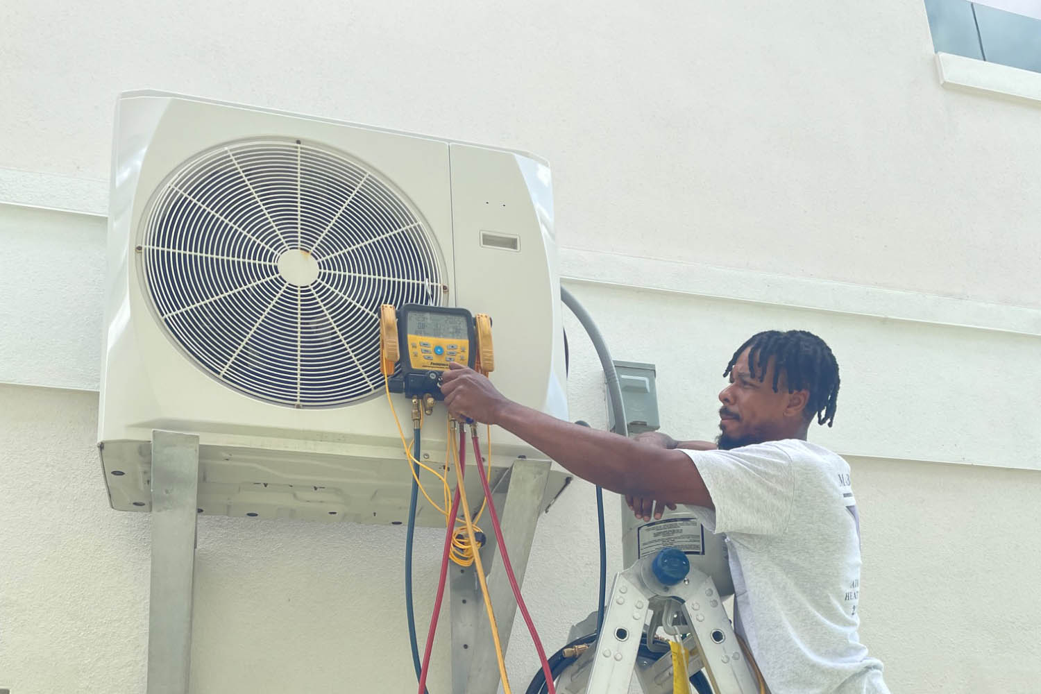 Mabry A/C technician checking lines on home HVAC unit