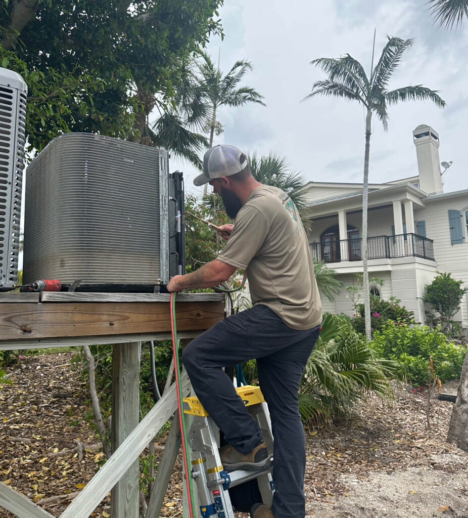 Mabry Brothers technician installing new air conditioning system outside SWFL property